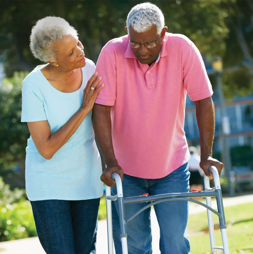 Elderly Black woman assisting her husband with mobility